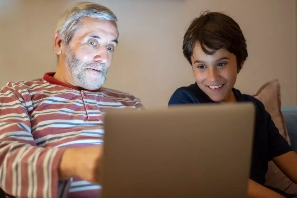 Immagine di signore anziano che utilizza un PC insieme a un bambino
